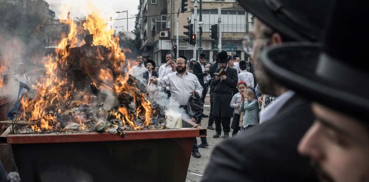 Judíos ortodoxos participan en el ritual tradicional de quema de jametz (alimentos fermentados) la mañana anterior a la Pascua judía en Bnei Brak, en el centro de Israel. La festividad judía de Pésaj, que dura ocho días, conmemora el éxodo de los israelitas de la esclavitud en Egipto y su difícil situación, absteniéndose de consumir alimentos fermentados.