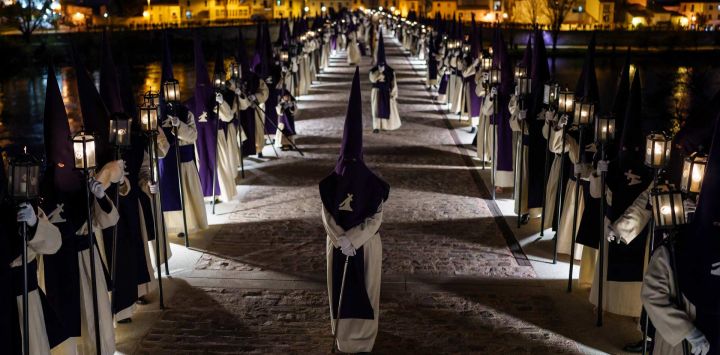 Penitentes de la Cofradía de Jesús del Vía Crucis desfilan sobre un puente durante una procesión de Semana Santa en la ciudad de Zamora, al noroeste de España. Las coloridas celebraciones de Semana Santa en España comenzaron esta semana, con procesiones centenarias de fieles que portan carrozas adornadas con flores y coronadas con estatuas de Cristo o la Virgen María, que congregan a multitudes.