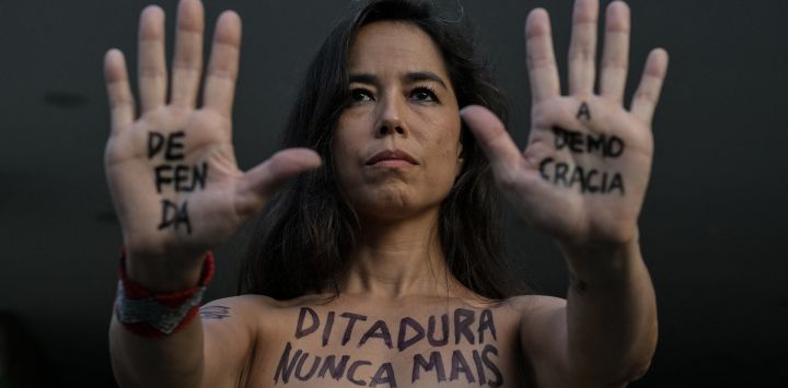 Una mujer con el cuerpo pintado con la inscripción “Dictadura nunca más” participa en una marcha silenciosa en memoria de las víctimas de la violencia estatal durante la dictadura de 1964 en São Paulo, Brasil.