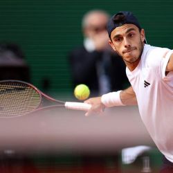 El argentino Francisco Cerundolo devuelve un golpe de derecha al griego Stefanos Tsitsipas durante el partido de dieciseisavos de final del torneo ATP Masters Series de Montecarlo, disputado en la pista Rainier III del Monte-Carlo Country Club en Roquebrune-Cap-Martin, al sureste de Francia. | Foto:Valery Hache / AFP