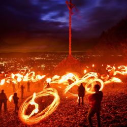 Los participantes ondean antorchas encendidas antes de encender el fuego pascual en una colina de Attendorn, en el oeste de Alemania. En Attendorn, se encienden enormes cruces en cuatro colinas. Además, se ondean antorchas encendidas con las que se dibujan círculos de fuego en el aire. | Foto:INA FASSBENDER / AFP