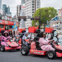Turistas extranjeros conducen karts y pasan junto a una gasolinera en Tokio. | Foto:Yuichi Yamazaki / AFP