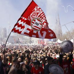 Los aficionados del PSV Eindhoven celebran el tercer título nacional consecutivo de la Eredivisie en la plaza Stadhuisplein de Eindhoven. El PSV Eindhoven se coronó campeón de los Países Bajos por vigésimo séptima vez, a falta de cinco partidos para el final de la temporada, tras el empate 0-0 del Feyenoord, segundo clasificado, con el Volendam. | Foto:Sem van der Wal / ANP / AFP
