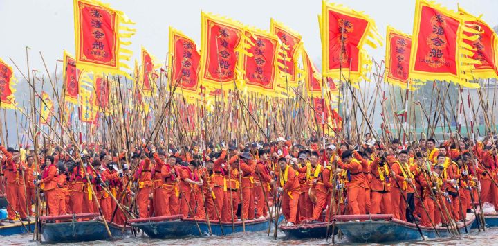 Barqueros impulsan los botes con pértigas para competir durante el Festival de Botes de Qintong, llevado a cabo en el Parque Nacional de Humedales de Qinhu, en la provincia de Jiangsu, en el este de China.