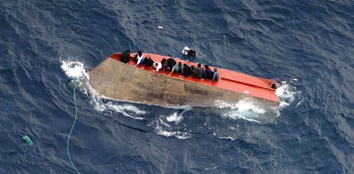 Esta foto tomda y distribuida por la ONG alemana Sea-Watch, muestra a migrantes sentados en una embarcación volcada frente a las costas de Libia. Decenas de personas están desaparecidas tras el naufragio de una embarcación de migrantes en el Mediterráneo central, según informaron las ONG Mediterranea Saving Humans y Sea-Watch en redes sociales. Dos personas fallecieron y 32 fueron rescatadas de la embarcación, que había zarpado de Libia con aproximadamente 105 personas a bordo, según Mediterranea Saving Humans.