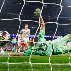 El arquero ucraniano del Real Madrid, Andriy Lunin, no logra detener el gol que puso el 0-2 parcial en el marcador, obra del delantero inglés del Bayern de Múnich, Harry Kane, durante el partido de ida de los cuartos de final de la Liga de Campeones de la UEFA entre el Real Madrid CF y el FC Bayern de Múnich, disputado en el estadio Santiago Bernabéu de Madrid. | Foto:Pierre-Philippe Marcou / AFP