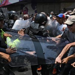 Opositores al gobierno de la presidenta interina venezolana Delcy Rodríguez se enfrentan a la policía durante una manifestación en Caracas para exigir aumentos salariales y de pensiones. | Foto:JUAN BARRETO / AFP