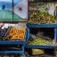 Fotogaleria Una mujer se encuentra junto a un puesto decorado con la bandera de Yibuti en un mercado al aire libre, mientras los residentes salen a las calles durante las horas más frescas de la tarde