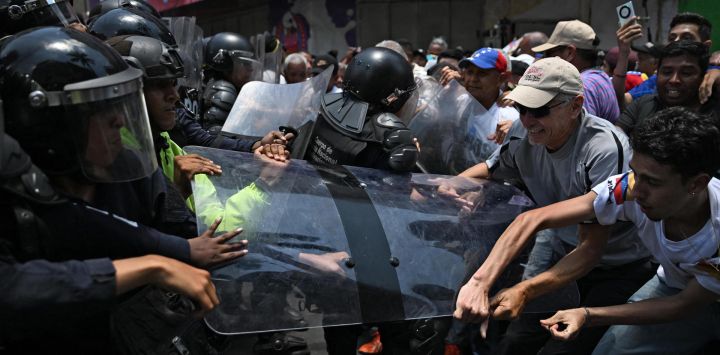 Opositores al gobierno de la presidenta interina venezolana Delcy Rodríguez se enfrentan a la policía durante una manifestación en Caracas para exigir aumentos salariales y de pensiones.