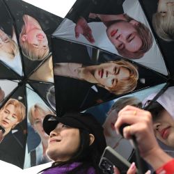 Los fans de BTS portan paraguas con la imagen de los miembros del grupo de K-pop BTS a su llegada al estadio donde el grupo actuará en Goyang. Las megaestrellas surcoreanas del K-pop, BTS, dieron inicio a su gira mundial aprovechando el éxito de su álbum de regreso, que alcanzó la cima de las listas, y una actuación histórica en el corazón de Seúl. | Foto:Jung Yeon-je / AFP