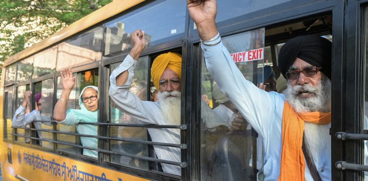 Peregrinos sij reaccionan al partir en autobús hacia Pakistán para celebrar el Baisakhi, la fiesta anual de la cosecha de primavera, en Amritsar, India.
