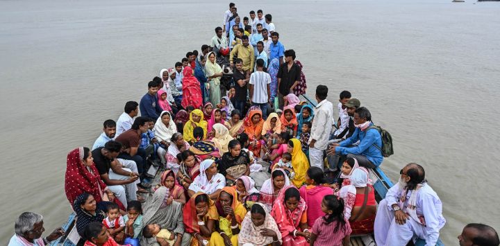 Varias personas viajan en barco a través del río Brahmaputra para emitir su voto en un colegio electoral durante las elecciones a la Asamblea Legislativa de Assam en el distrito de Darrang, India.
