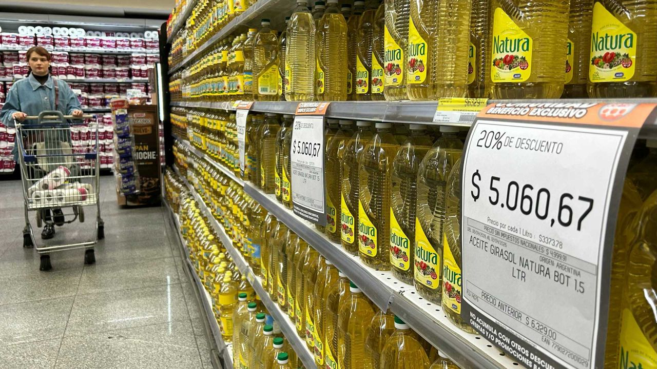 Una mujer empuja un carrito de compras frente a un puesto de aceite de girasol en venta en un supermercado de Buenos Aires. | Foto:AFP