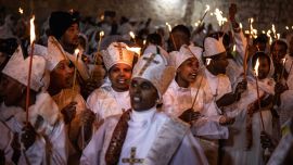 Los fieles cristianos ortodoxos etíopes cantan y bailan mientras sostienen velas durante su ceremonia anual del Fuego Sagrado en la Iglesia del Santo Sepulcro de Jerusalén.