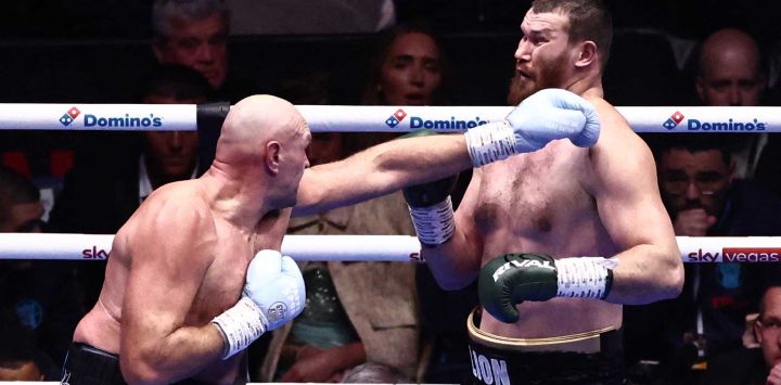 El británico Tyson Fury (izquierda) lanza un jab contra el ruso Arslanbek Makhmudov (derecha) durante su combate de peso pesado "Choque de Gigantes" en el estadio del Tottenham Hotspur en Londres.