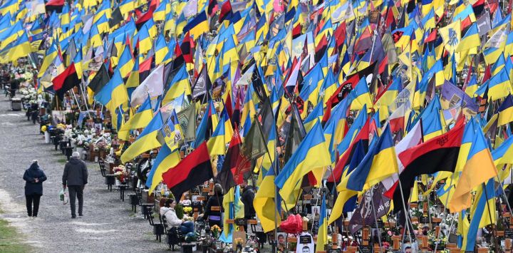 En medio de la invasión rusa de Ucrania, personas visitan las tumbas de soldados ucranianos caídos en el cementerio militar de Lychakiv durante las celebraciones de la Pascua ortodoxa en Lviv.