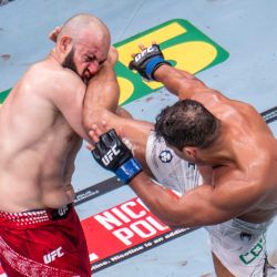 El peso semipesado brasileño Paulo Costa patea al ruso Azamat Murzakanov, hasta entonces invicto, antes de que este caiga noqueado técnicamente (TKO) durante el UFC 327 en el Kaseya Center de Miami. | Foto:JIM WATSON / AFP
