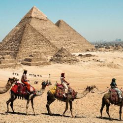 Imagen de turistas paseando en camello en el punto escénico de las Pirámides de Giza, en Giza, Egipto. Las Pirámides de Giza, ubicadas en el suroeste de El Cairo, capital de Egipto, son uno de los sitios más representativos de la antigua civilización egipcia. El complejo incluye las tres pirámides conocidas como las Grandes Pirámides, la imponente escultura conocida como la Gran Esfinge, y varios cementerios antiguos y pirámides más pequeñas. | Foto:Xinhua/Xin Mengchen