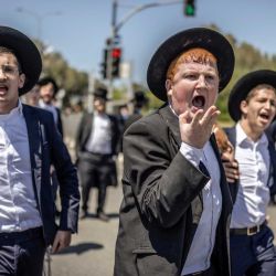 Judíos ultraortodoxos, en su mayoría exentos del servicio militar, protestan contra el reclutamiento obligatorio a la entrada de Tel Hashomer, el centro de reclutamiento del ejército israelí, en Ramat-Gan. El primer ministro de Israel, que depende de sus aliados del partido ultraortodoxo para mantenerse en el poder, ha empleado diversas tácticas para retrasar la aprobación de la legislación que permitiría el alistamiento de los judíos ultraortodoxos, quienes gozan de una amplia exención del servicio militar. Según una normativa establecida en la creación del país en 1948 —cuando la comunidad ultraortodoxa era pequeña—, los hombres que se dedican a tiempo completo al estudio de los textos sagrados judíos reciben una exención de facto. | Foto:ilia yefimovich / AFP