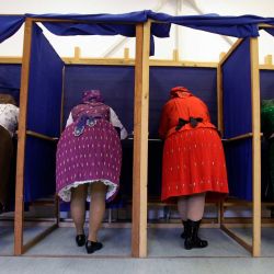 Mujeres con trajes tradicionales húngaros rellenan sus papeletas en un colegio electoral ubicado en una guardería de Veresegyhaz, a unos 30 km al este de Budapest, durante las elecciones generales en Hungría. La votación podría poner fin a los 16 años de mandato del primer ministro húngaro Viktor Orbán, el líder que más tiempo ha permanecido en el cargo en la UE y autodenominado una "espina clavada" en el bloque. | Foto:Peter Kohalmi / AFP