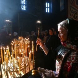 Un fiel ortodoxo enciende una vela durante la misa de Pascua en la Catedral de San Miguel de la Cúpula Dorada en Kiev, en medio de la invasión rusa de Ucrania. Ucrania y Rusia se acusaron mutuamente ese mismo día de haber violado miles de veces la tregua establecida para la Pascua ortodoxa, mientras la guerra se prolongaba por quinto año. | Foto:SERGEI SUPINSKY / AFP