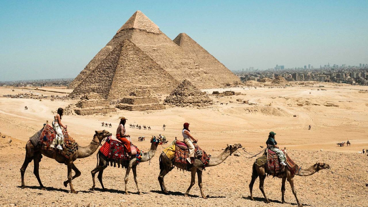 Imagen de turistas paseando en camello en el punto escénico de las Pirámides de Giza, en Giza, Egipto. Las Pirámides de Giza, ubicadas en el suroeste de El Cairo, capital de Egipto, son uno de los sitios más representativos de la antigua civilización egipcia. El complejo incluye las tres pirámides conocidas como las Grandes Pirámides, la imponente escultura conocida como la Gran Esfinge, y varios cementerios antiguos y pirámides más pequeñas. | Foto:Xinhua/Xin Mengchen