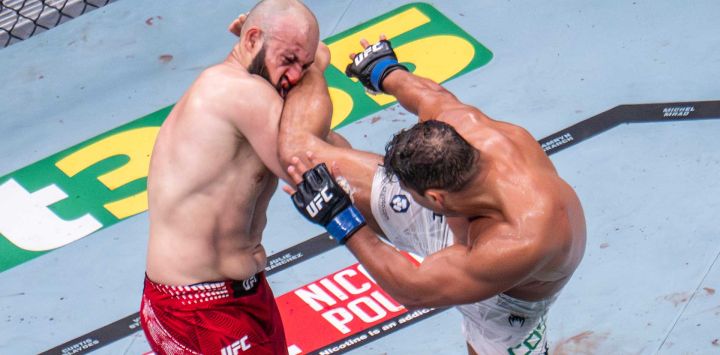 El peso semipesado brasileño Paulo Costa patea al ruso Azamat Murzakanov, hasta entonces invicto, antes de que este caiga noqueado técnicamente (TKO) durante el UFC 327 en el Kaseya Center de Miami.