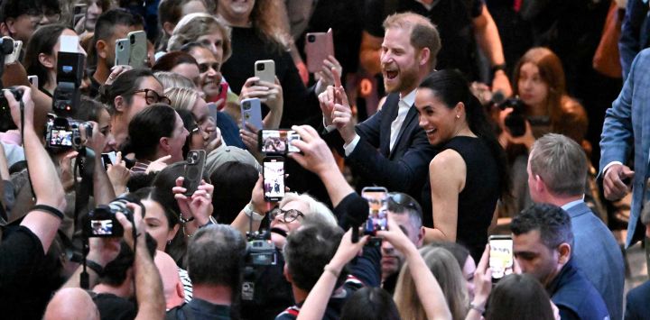 El príncipe Harry de Gran Bretaña, duque de Sussex, y su esposa Meghan, duquesa de Sussex, saludan a la gente en el Hospital Real Infantil de Melbourne, Australia.