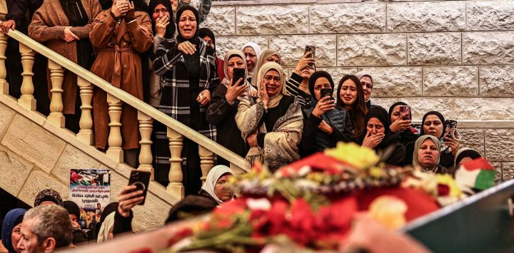 Familiares de Ali Majed Hamadneh, de 23 años, se reúnen durante su funeral en la aldea de Deir Jarir, al noreste de la ciudad de Ramallah, en la Cisjordania palestina ocupada por Israel. El Ministerio de Salud palestino informó que colonos israelíes asesinaron a tiros a Hamadneh en la Cisjordania ocupada, mientras que el ejército afirmó que un soldado abrió fuego durante un "violento disturbio". La violencia en Cisjordania, ocupada por Israel desde 1967, se ha intensificado drásticamente desde el ataque de Hamás contra Israel el 7 de octubre de 2023, que desencadenó la guerra de Gaza.