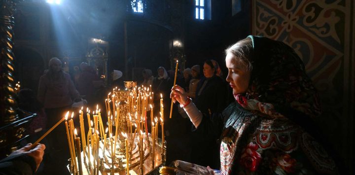 Un fiel ortodoxo enciende una vela durante la misa de Pascua en la Catedral de San Miguel de la Cúpula Dorada en Kiev, en medio de la invasión rusa de Ucrania. Ucrania y Rusia se acusaron mutuamente ese mismo día de haber violado miles de veces la tregua establecida para la Pascua ortodoxa, mientras la guerra se prolongaba por quinto año.