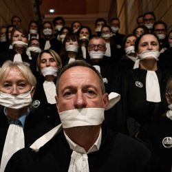 Abogados se congregan con la boca tapada con cinta adhesiva frente al juzgado de Chambery, durante una manifestación contra el proyecto de ley "SURE" (Sentencia Útil, Rápida y Efectiva), en particular su propuesta de introducir la negociación de penas en materia penal, mientras el Senado francés inicia el debate del texto, en Chambery. Abogados de toda Francia protagonizaron un paro nacional de "Justicia Muerta" convocado por la mayoría de los 164 colegios de abogados del país, al tiempo que el Senado iniciaba el debate sobre el proyecto de ley que, según el gobierno, es necesario para abordar el retraso de más de 6.000 casos penales pendientes. | Foto:JEFF PACHOUD / AFP