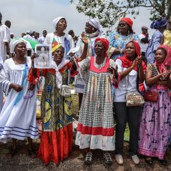 Los fieles cantan mientras esperan la llegada del Papa León XIV al Aeropuerto Internacional de Yaundé Nsimalen, en Yaundé, en el tercer día de un viaje apostólico de 11 días a África. | Foto:DANIEL BELOUMOU OLOMO / AFP