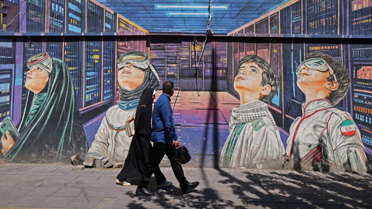 Varias personas caminan junto a un mural en la acera de Teherán. El presidente del Parlamento iraní, Mohammad Bagher Ghalibaf, quien participó en las conversaciones de paz con Estados Unidos este fin de semana, declaró que Washington fue "incapaz" de ganarse la confianza de Teherán durante las negociaciones. | Foto:ATTA KENARE / AFP