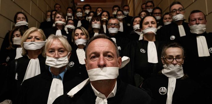 Abogados se congregan con la boca tapada con cinta adhesiva frente al juzgado de Chambery, durante una manifestación contra el proyecto de ley "SURE" (Sentencia Útil, Rápida y Efectiva), en particular su propuesta de introducir la negociación de penas en materia penal, mientras el Senado francés inicia el debate del texto, en Chambery. Abogados de toda Francia protagonizaron un paro nacional de "Justicia Muerta" convocado por la mayoría de los 164 colegios de abogados del país, al tiempo que el Senado iniciaba el debate sobre el proyecto de ley que, según el gobierno, es necesario para abordar el retraso de más de 6.000 casos penales pendientes.