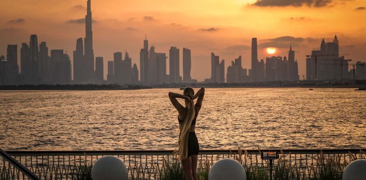 Una mujer practica yoga frente al horizonte de Dubái, con el Burj Khalifa, el edificio más alto del mundo, visto desde Creek Harbour.