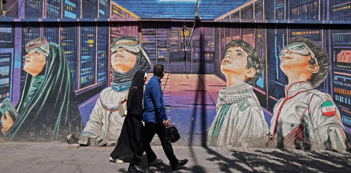 Varias personas caminan junto a un mural en la acera de Teherán. El presidente del Parlamento iraní, Mohammad Bagher Ghalibaf, quien participó en las conversaciones de paz con Estados Unidos este fin de semana, declaró que Washington fue "incapaz" de ganarse la confianza de Teherán durante las negociaciones.