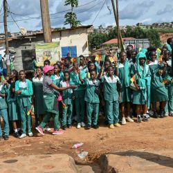Niños ondean banderas camerunesas al paso de la comitiva del Papa León XIV tras su llegada al Aeropuerto Internacional de Yaundé-Nsimalen, en Yaundé, en el tercer día de su viaje apostólico de 11 días a África. | Foto:ALBERTO PIZZOLI / AFP