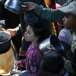 Niños palestinos desplazados reciben comida de un comedor social en el campamento de refugiados de Nuseirat, en el centro de la Franja de Gaza. Desde que entraron en vigor los términos del acuerdo de alto el fuego negociado por Estados Unidos el 10 de octubre, Israel mantiene el control de casi la mitad de la Franja de Gaza, incluidas todas sus zonas fronterizas. Cerca de dos millones de personas en Gaza viven en refugios improvisados, y la situación humanitaria sigue siendo crítica, según las agencias de ayuda. | Foto:Eyad Baba / AFP