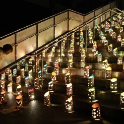 Una mujer observa las luces instaladas para conmemorar a las víctimas del terremoto de Kumamoto de 2016, en el Parque Deportivo de la Aldea de Nishihara, en la prefectura de Kumamoto, Japón. | Foto:JIJI PRESS / AFP