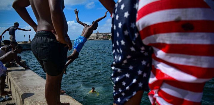 Jóvenes se bañan en el mar frente al Malecón de La Habana, Cuba.