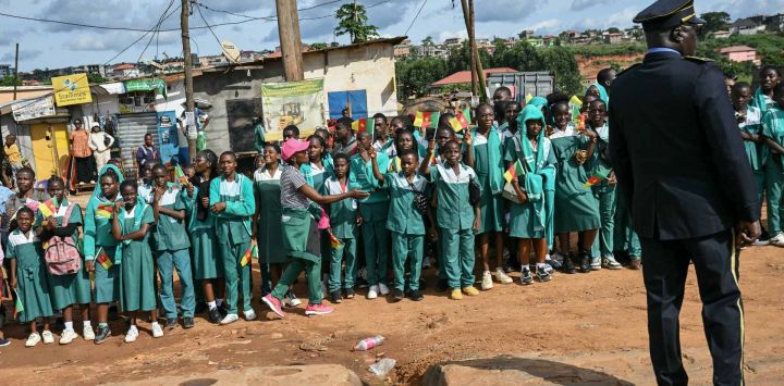 Niños ondean banderas camerunesas al paso de la comitiva del Papa León XIV tras su llegada al Aeropuerto Internacional de Yaundé-Nsimalen, en Yaundé, en el tercer día de su viaje apostólico de 11 días a África.