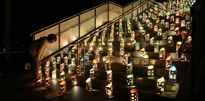 Una mujer observa las luces instaladas para conmemorar a las víctimas del terremoto de Kumamoto de 2016, en el Parque Deportivo de la Aldea de Nishihara, en la prefectura de Kumamoto, Japón.