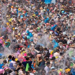 Personas celebran el festival de salpicaduras de agua en una plaza, en Jinghong, en la prefectura autónoma de la etnia dai de Xishuangbanna, en la provincia de Yunnan, en el suroeste de China. El festival de salpicaduras de agua es considerado uno de los más importantes de los grupos étnicos del suroeste de China. Durante el festival, el agua se considera un símbolo de buen augurio y las personas se salpican unos a otros, deseándose así felicidad y buena fortuna. | Foto:Xinhua/Jiang Wenyao