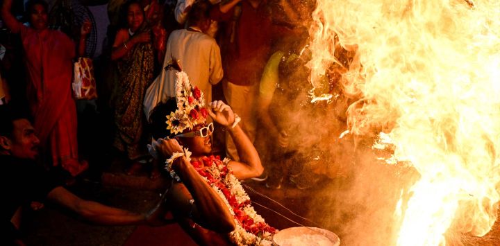 Devotos hindúes encienden polvo sagrado inflamable mientras realizan rituales para celebrar el Festival Gajan en Calcuta, India.