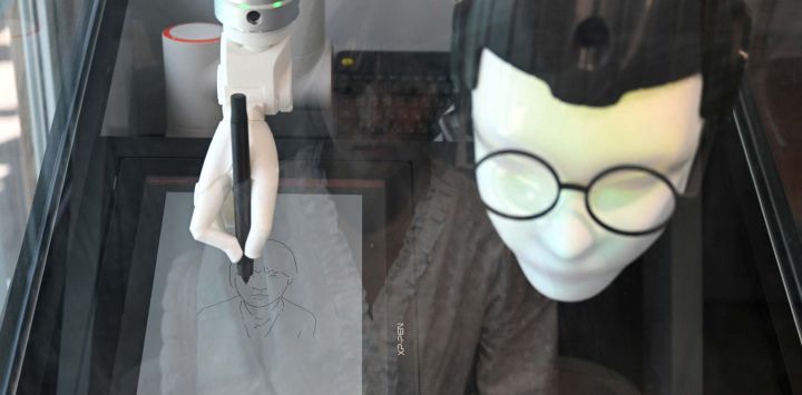 Esta fotografía, muestra a un robot chamán con gafas que ofrece servicios de lectura facial para predecir el futuro mientras dibuja un retrato, en una tienda temática de chamanismo coreano en Seúl. El tintineo de campanillas resuena en un callejón del centro de Seúl, una señal inequívoca de la presencia de un chamán, aunque en este caso el místico es un robot impulsado por inteligencia artificial.
