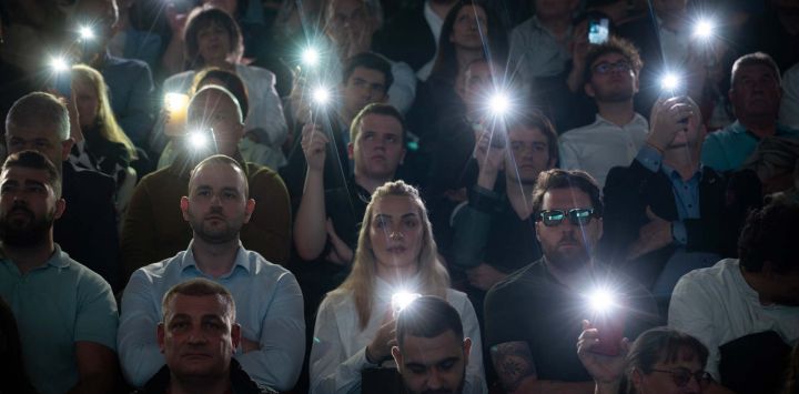 Simpatizantes alumbran con sus teléfonos móviles durante el último acto preelectoral de la coalición política "Bulgaria Progresista" del expresidente búlgaro Rumen Radev en Sofía.