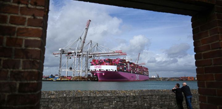 Varias personas observan el buque de carga One Inspiration, registrado bajo la bandera de Liberia, mientras se carga en la terminal de contenedores de Southampton Docks, en Southampton, en la costa sur de Inglaterra.
