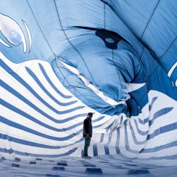 Un participante camina a través de una cometa con forma de ballena durante el 39º Festival Internacional de Cometas (RICV) en la playa de Berck-sur-Mer, al norte de Francia. Unos 450 aficionados a las cometas de 28 países asistieron al 39º Festival Internacional de Cometas de Berck-sur-Mer. | Foto:SAMEER Al-DOUMY / AFP