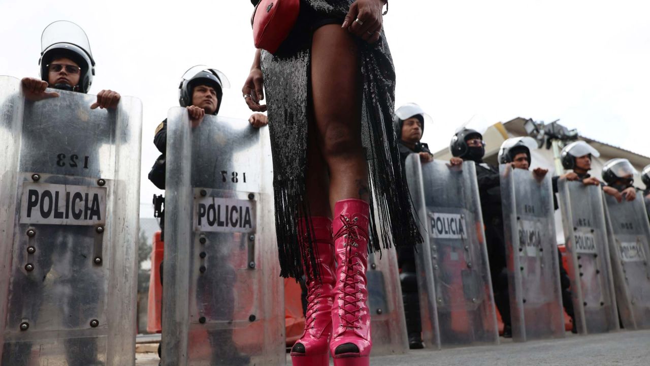 Una trabajadora sexual transgénero, se planta frente a agentes de la policía antidisturbios mexicana durante una protesta contra el carril bici Gran Tenochtitlán y la organización del Mundial de México en la Ciudad de México. El Gran Tenochtitlán es un proyecto de infraestructura diseñado para conectar el Estadio Banorte (antes Estadio Azteca) con otros puntos de interés de la Ciudad de México, según el gobierno local. | Foto:LUIS CORTES / AFP