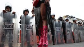 Una trabajadora sexual transgénero, se planta frente a agentes de la policía antidisturbios mexicana durante una protesta contra el carril bici Gran Tenochtitlán y la organización del Mundial de México en la Ciudad de México. El Gran Tenochtitlán es un proyecto de infraestructura diseñado para conectar el Estadio Banorte (antes Estadio Azteca) con otros puntos de interés de la Ciudad de México, según el gobierno local.